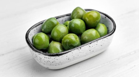 Photo for Sweet green olives in plate, mediterranean vegetarian delicatessen. Delicious snack appetizer from Greece - Royalty Free Image