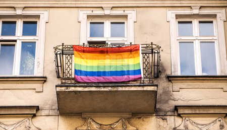 Téléchargez les photos : Drapeau LGBTQ sur le balcon de vieux bâtiments comme symbole de solidarité et de liberté. Signe d'égalité et de soutien des relations homosexuelles, lesbiennes et bisexuelles - en image libre de droit