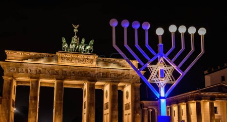 Foto de Brandenburg Gate and lightning Jewish menorah on a square against Gates in Berlin at night - Imagen libre de derechos