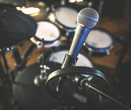 Téléchargez les photos : Microphone and drums in recording studio for live music perfomance closeup. Mic stage for rock and pop vocal presentation - en image libre de droit