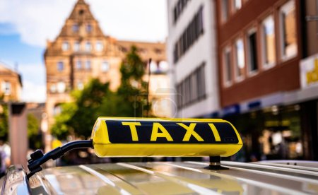 Señal amarilla de taxi en el casco antiguo de Alemania de cerca. Tablero de servicio de taxi en coche en la antigua calle de la ciudad de europen