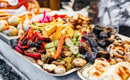 Photo for Variety of grilled vegetables as eggplant, zucchini and garlic at street food market. Traditional fried veggies at outdoor fair - Royalty Free Image