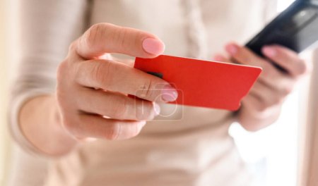Photo for Girl with smartphone, credit card shopping online. Woman making purchases in internet and paying with debit using cell mobile phone - Royalty Free Image