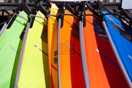 Foto de Coloridas tablas de paddle surf en un día soleado en la playa. Escritorios de agua para relajarse en el océano y el mar - Imagen libre de derechos