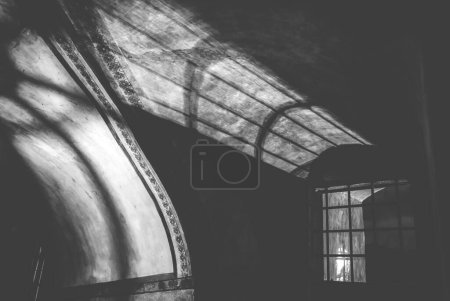Photo for Shadows from the lattice in a mysterious corridor in the old room of the castle, black and white - Royalty Free Image