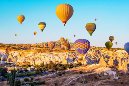 Foto de Coloridos globos de aire caliente sobre Capadocia, Turquía al amanecer. Increíble vista sobre el valle histórico y la ciudad antigua Goreme - Imagen libre de derechos