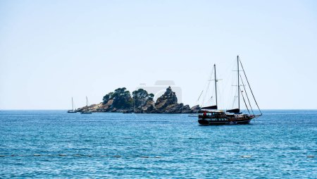 Foto de Barco turístico en el mar Adriático en Montenegro cerca de la isla en el día soleado. Hermosa naturaleza mediterránea - Imagen libre de derechos