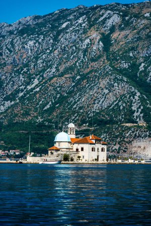 Foto de Isla de San Jorge en Montenegro, vista desde la bahía de Kotor. Antigua arquitectura de balcanes en el mar Adriático rodeado de montañas - Imagen libre de derechos