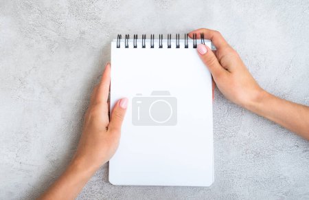 Photo for Girl holding white notebook view from above - Royalty Free Image