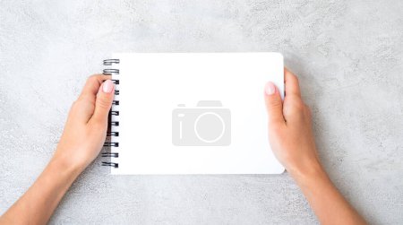 Photo for Girl holding white notebook view from above - Royalty Free Image