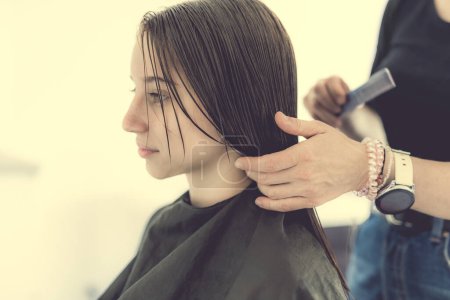 Photo for Hairdresser preparing hair of girl for haircut. Female child in beauty salon - Royalty Free Image