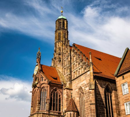Foto de Antigua fachada del edificio Iglesia de la Virgen María en el centro de la ciudad vieja en Nuremberg, Alemania. Casa histórica exterior con techo rojo típico en Baviera, Europa - Imagen libre de derechos