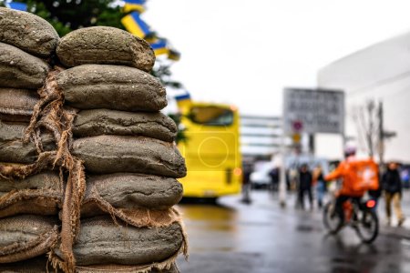 Téléchargez les photos : Sacks with sand at Checkpoint Charlie against hop-on hop-off touristic bus. The crossing point between East and west Berlin, symbol of the Cold War. - en image libre de droit