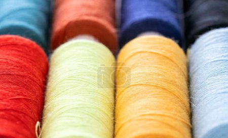 Photo for Colorful sewing threads in spools for sew hobby closeup. Macro bobbins for clothing repair - Royalty Free Image