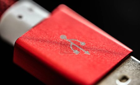 Foto de Conector USB rojo para smartphone y gadgets de primer plano sobre fondo negro. Cable de enchufe para la vista macro de recarga del dispositivo - Imagen libre de derechos