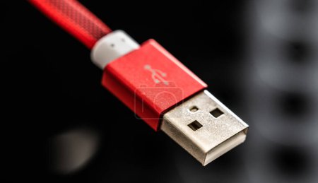 Photo for Red USB connector for smartphone and gadgets closeup on black background. Plug cable for mobile devices in macro - Royalty Free Image