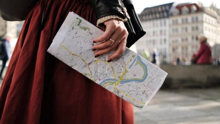 Téléchargez les photos : Promenades touristiques féminines dans les rues centrales de Dresde, portant la carte de la ville avec des visites - en image libre de droit