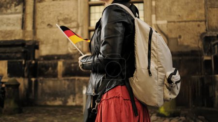 Téléchargez les photos : Attrayant touriste féminine avec l'Allemagne Drapeau Promenades dans le centre historique de Dresde sac à dos de transport - en image libre de droit