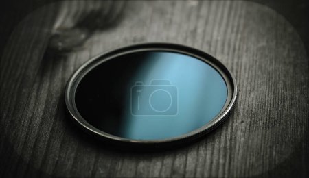 Téléchargez les photos : Filtre ND pour la prise de vue photo et vidéo sur une table en bois noir - en image libre de droit