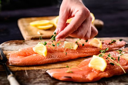 Photo for Girl decorating at fillet trout red fish for cooking a healthy dinner - Royalty Free Image
