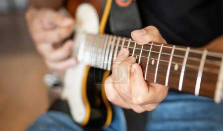 Photo for Man hand playing on electric guitar closeup. Musician performing live with acoustic string instrument with fretboard - Royalty Free Image