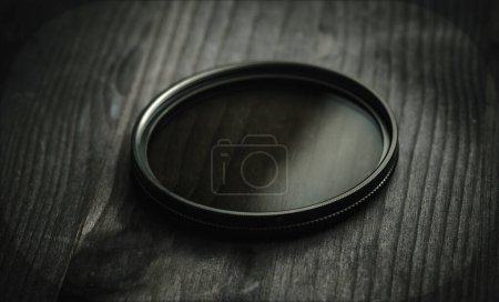 Téléchargez les photos : Filtre à densité neutre ou filtre ND pour prise de vue photo et vidéo sur une table en bois noir - en image libre de droit