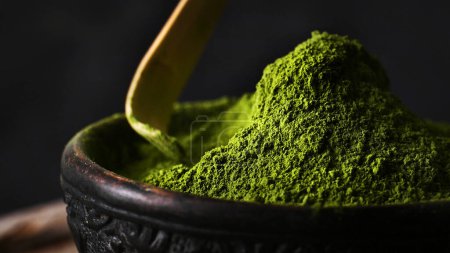 Photo for Matcha green tea powder hill in a bowl with spoon close up view - Royalty Free Image