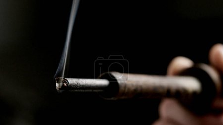 Photo for Soldering iron ready to solder with smoke on black background, close up - Royalty Free Image