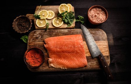Téléchargez les photos : Filet de poisson rouge saumon avec épices et citron sur une planche à découper vue de dessus - en image libre de droit