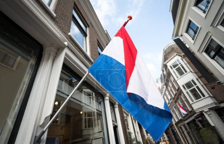 Foto de Ondeando la bandera de Holanda en el edificio fasad contra Blue Sky - Imagen libre de derechos
