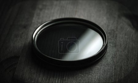 Téléchargez les photos : Filtre à densité neutre pour la prise de vue photo et vidéo sur une table en bois noir - en image libre de droit