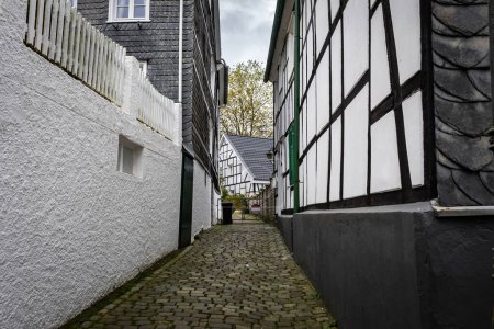 Foto de Calle estrecha con adoquines entre casas blancas tradicionales en la pequeña ciudad alemana - Imagen libre de derechos