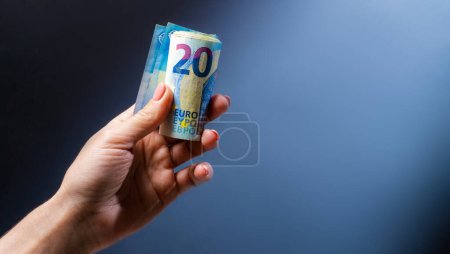 Téléchargez les photos : Main tenant vingt billets en euros. Monnaie européenne en espèces et en argent comme symbole de réussite et de richesse - en image libre de droit
