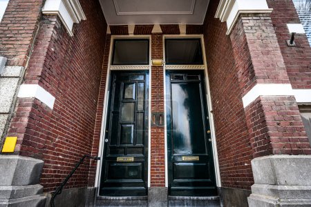 Téléchargez les photos : Portes dans le bâtiment résidentiel européen en brique. Entrée de maison et façade traditionnelle en pierre - en image libre de droit