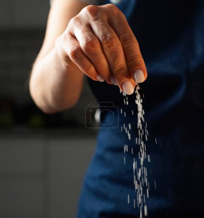 Téléchargez les photos : Femme sel la nourriture avec une pincée de sel, Fermer - en image libre de droit