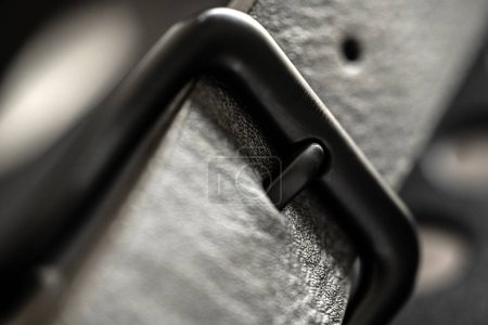 Foto de Cinturón de cuero negro con hebilla de acero metálico macro view. Ropa accesorio masculino con elegancia diseño casual - Imagen libre de derechos