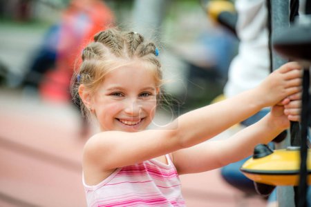 Foto de Retrato de la niña sonriente feliz jugando en el patio de recreo y subir las cuerdas al aire libre - Imagen libre de derechos