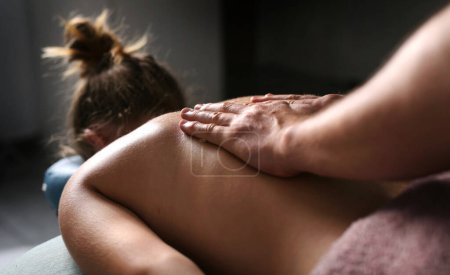 Foto de Relajarse procedimientos de masaje en un salón de belleza, Masaje profesional haciendo masaje de espalda para niña - Imagen libre de derechos