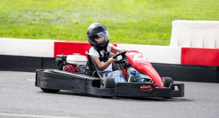 Téléchargez les photos : Petite fille conduit des enfants rapides Go-Kart par piste de course - en image libre de droit