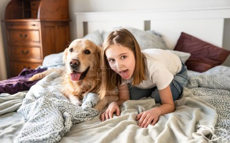 Téléchargez les photos : Joyeuse petite fille jouant avec Golden Retriever chien et bâton sur les langues - en image libre de droit