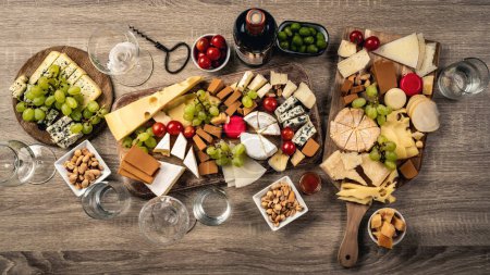 Photo for Variety of cheese kinds served with grape, honey and olives for gourmet nutrition. Organic parmesan, brie and camambert set with nuts - Royalty Free Image