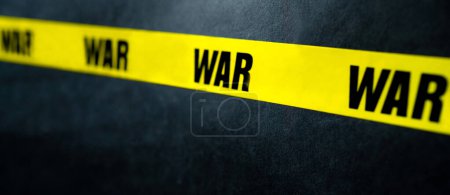 Foto de Raya de cinta amarilla de advertencia con texto de guerra como advertencia Detenga el conflicto militar. Concepto de invasión, peligro y verdad - Imagen libre de derechos