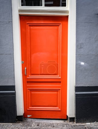Photo for Traditional red door with design in black residential building. House entrance in european city - Royalty Free Image