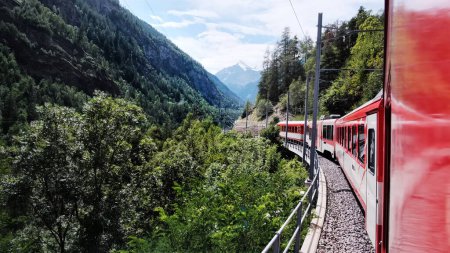 Photo for Red Swiss Train Moving By Valley In Mountains In Switzerland - Royalty Free Image