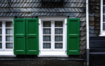 Foto de Ventana con persianas verdes abiertas, exterior tradicional de la casa de pizarra de Alemania - Imagen libre de derechos