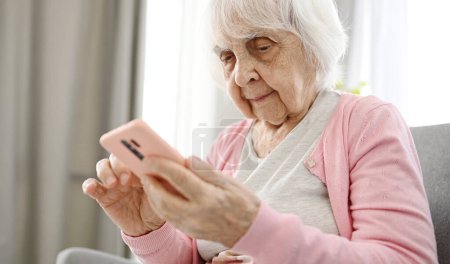 Mujer mayor usando Smartphone lectura de noticias de Internet, Vista de cerca