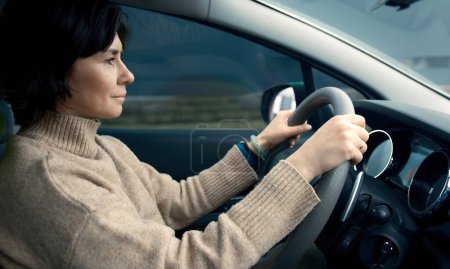 Téléchargez les photos : Femme conduisant sa voiture à travers la campagne - en image libre de droit