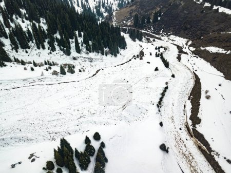 View of an avalanche in a mountain gorge. View from a drone. Consequences of sudden warming