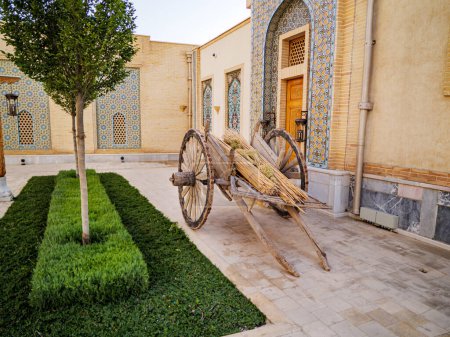 An ancient wooden cart in the street of the historical and ethnographic park in the Eternal City complex of the Boki Shakhar Registan in Samarkand, Uzbekistan.