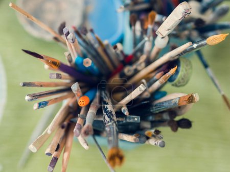 Une vue aérienne des outils de l'artiste céramique. Les piles, pétoncles, crayons et pinceaux sont disposés en grandes quantités dans un verre spécial.